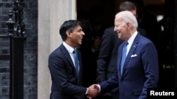 Perdana Menteri Inggris Rishi Sunak berjabat tangan dengan Presiden AS Joe Biden setelah pertemuan mereka di Downing Street 10 di London, 10 Juli 2023. (Foto: Reuters)