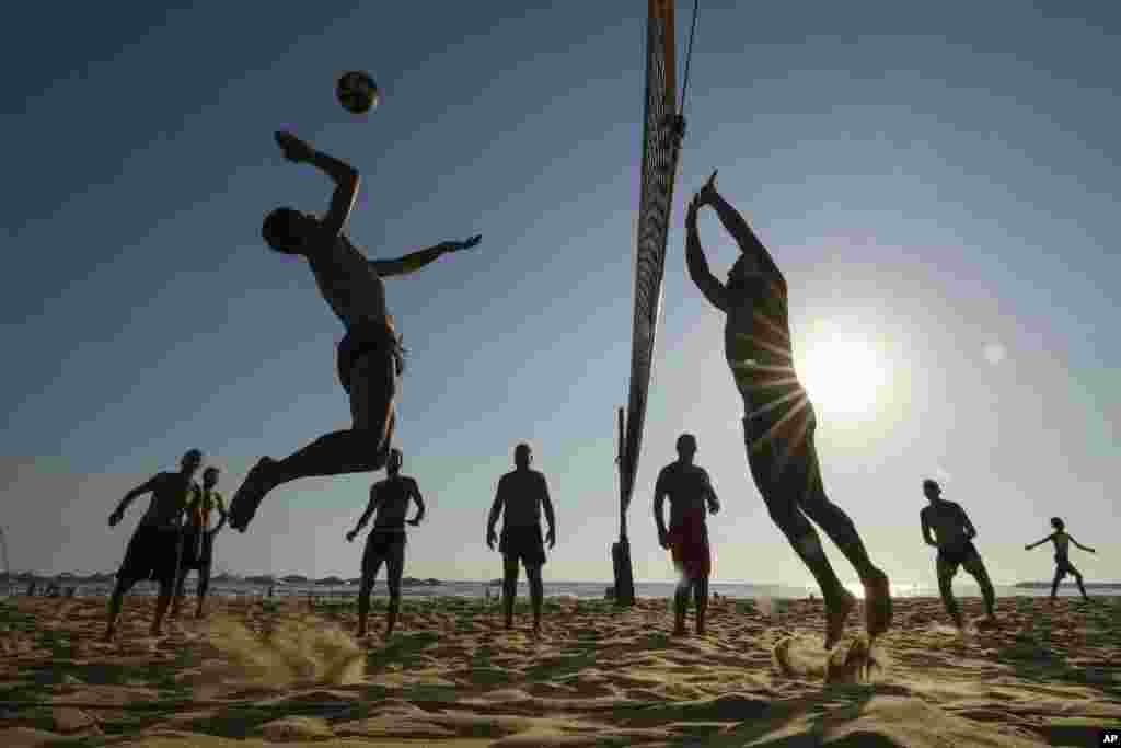 Men play beach volley ball on a sweltering hot day at the Ramlet al-Baida public beach in Beirut, Lebanon.