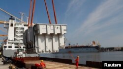 Situasi di pelabuhan Klaipeda, Lituania, pada 13 Mei 2021, saat sejumlah kapal kargo melakukan bongkar muat barang di pelabuhan tersebut. (Foto: Reuters/Ints Kalnins)