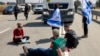资料照片：以色列抗议者在凯雷姆沙洛姆过境点的以色列一侧拦路，挡住运载着人道主义物资前往加沙的约旦卡车。(2024年4月16日)