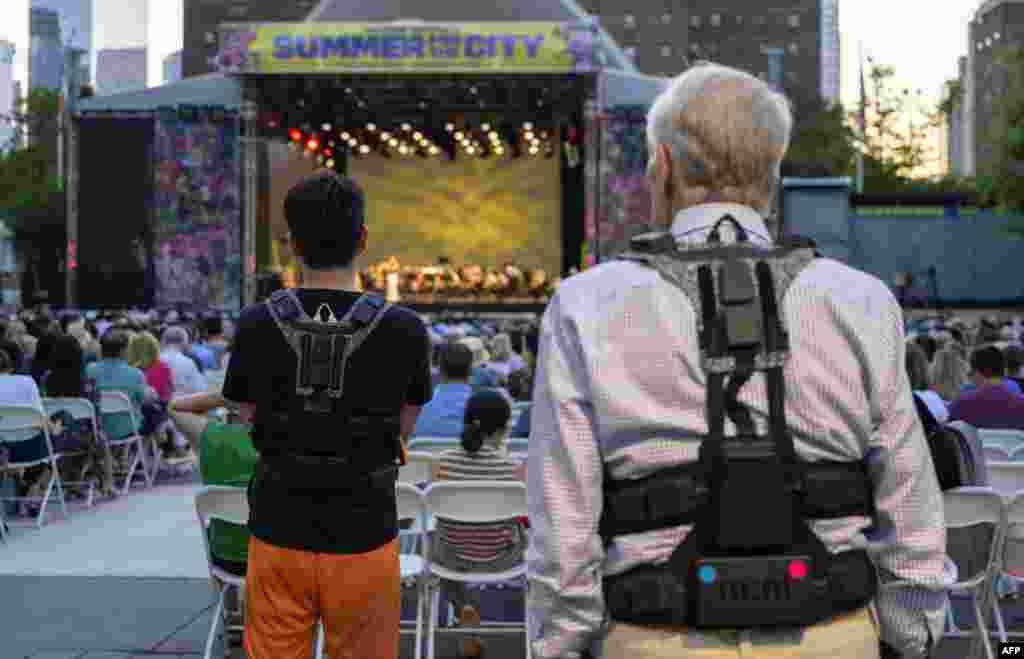 Fans wear haptic suits created for the deaf by Music: Not Impossible, during an outdoor concert at Lincoln Center in New York City. The vests have 24 points of vibration to translate the music that is being played. Audio expert Patrick Hanlon programs the wireless haptic suits that are designed to enable the deaf or hard of hearing to experience orchestral music, as initiatives break new ground to improve inclusivity at live music performances.
