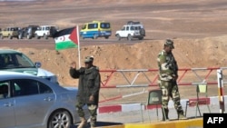 Un drapeau du Sahara occidental flotte à un poste de contrôle tenu par des membres des forces de sécurité sahraouies à l'extérieur du camp de réfugiés de Dakhla.