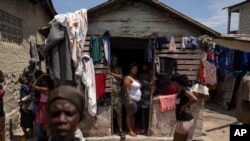 Orang-orang yang terlantar akibat kekerasan geng berdiri di halaman depan Jean-Kere Almicar, tempat mereka mengungsi, di Port-au-Prince, Haiti, 4 Juni 2023. (Foto: AP)