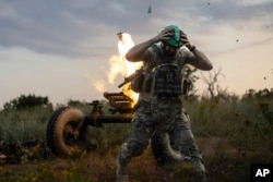 A Ukrainian serviceman of the 3rd Assault Brigade fires a 122mm mortar toward Russian positions at the front line, near Bakhmut, Donetsk region, Ukraine, July 2, 2023.