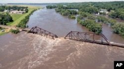 Floodwaters pass over a collapsed railroad bridge over the Big Sioux River near North Sioux City, South Dakota, June 24, 2024.