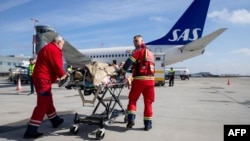 Ukrainian medical personnel transport a wounded soldier to a medical evacuation (Medevac) airplane, a specially-adapted Boeing 737, for a flight carried out by Norway in collaboration with the European Union in Rzeszow, Poland on March 22, 2023.