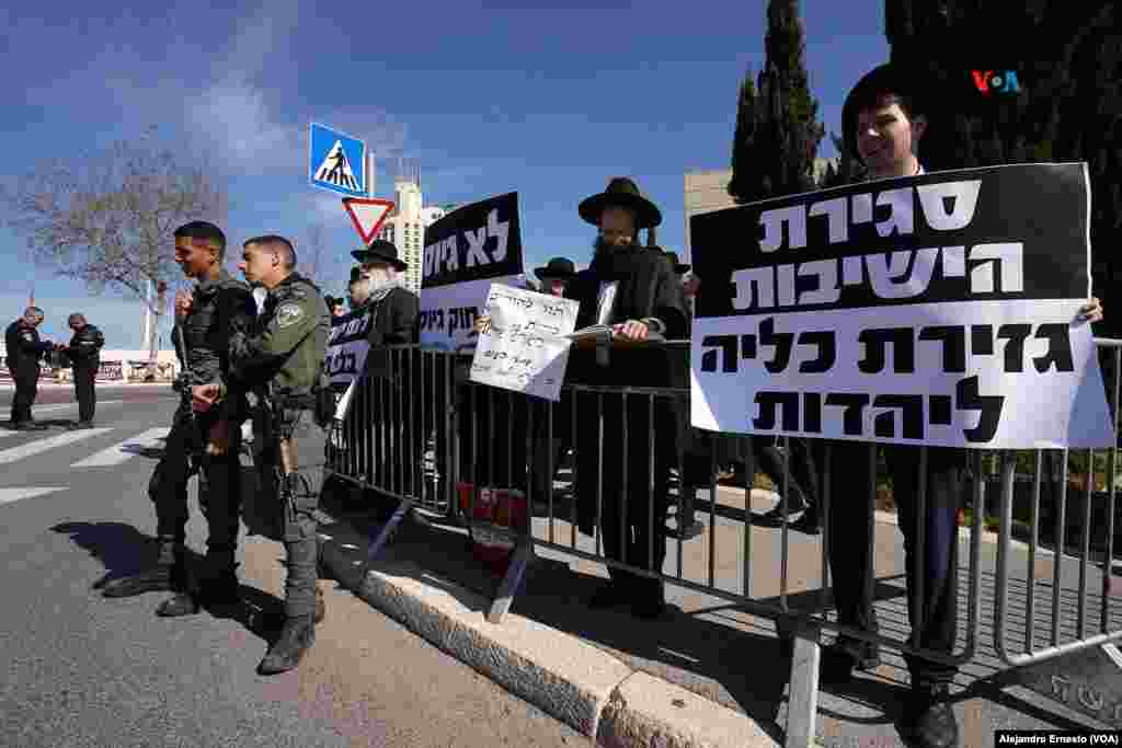 Un pequeño grupo de judíos ultraortodoxos se manifiesta con carteles como "No nos alistaremos" o "El cierre de las yeshivas (escuelas religiosas) es un ataque contra el judaísmo".