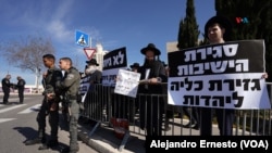 Un pequeño grupo de judíos ultraortodoxos se manifiesta con carteles como "No nos alistaremos" o "El cierre de las yeshivas (escuelas religiosas) es un ataque contra el judaísmo".