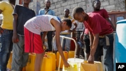 FILE - Residents fill their containers with potable water in Port-au-Prince, Haiti, March 8, 2024.