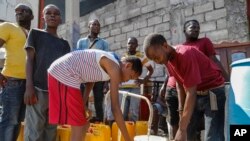 (FILE) Residents fill their containers with potable water in Port-au-Prince, Haiti, March 8, 2024. 