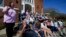 Rev. Mary Stewart, left, of Rolling Fork United Methodist Church, leads a prayer as people affected by Friday's tornado worship on the steps of the church, in Rolling Fork, Mississippi, March 26, 2023.
