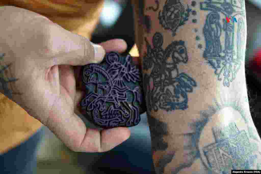 Wassim Razzouk, actual dueño del negocio familiar Razzouk Tattoo, muestra el tatuaje de San Jorge que lleva en su antebrazo hecho con un sello de madera que lleva en su familia más de 500 años.