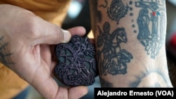 Wassim Razzouk, actual dueño del negocio familiar con sede en Jerusalén, muestra el tatuaje de San Jorge que lleva en su antebrazo, hecho con un sello de madera que lleva en su familia más de 500 años.