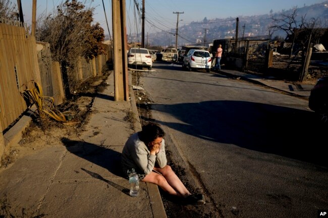 A woman cries after losing a friend who died after a forest fire reached Villa Independencia neighborhood in Vina del Mar, Chile, Feb. 3, 2024.