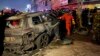 Pripadnici civilne zaštite okupljaju se oko vozila unišenog u napadu drona američke vojske, u istočnom Bagdadu, Iraj, 7. februara 2024.