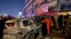 2024年2月7日，伊拉克巴格达东部，民防军聚集在一辆被美国无人机袭击烧毁的车辆现场。