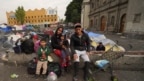 Gia đình Aguilar Bastida, đến từ Venezuela, ngồi bên ngoài Nhà thờ Santa Cruz y La Soledad nơi các di dân cắm trại tại Mexico City, ngày 26/12/2023.
