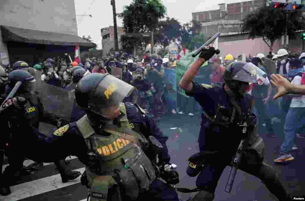 Riot police officers use batons against demonstrators during a protest of Peruvian President Dina Boluarte in Lima, Peru, July 19, 2023.