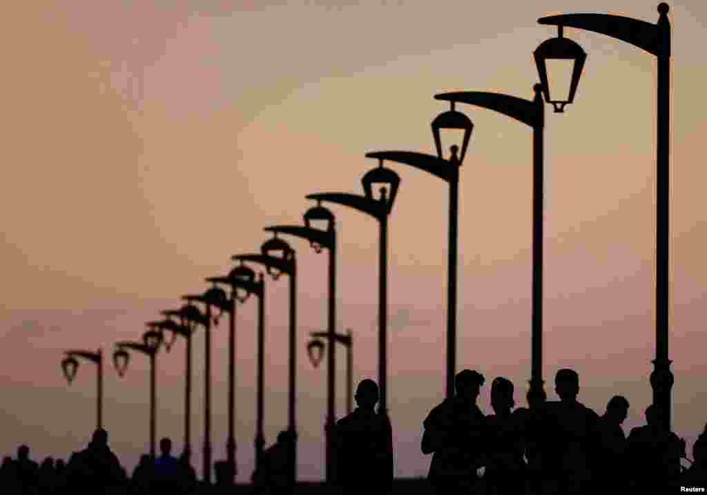 People walk at Beirut&#39;s seaside corniche during sunset, Lebanon.