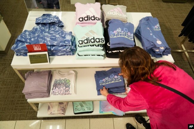 A merchandiser arranges clothing at a Kohl's store in Clifton, N.J., Friday, Jan. 26, 2024. (AP Photo/Seth Wenig)