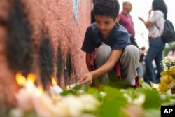 FILE - A student from the Thomazia Montoro public school lights a candle during a vigil asking for peace the day after a student stabbed a teacher to death at the school in Sao Paulo, Brazil, March 28, 2023. (AP Photo/Andre Penner, File)