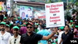 A BNP activist holds a poster at a Dhaka, Bangladesh, protest rally July 12, 2023, saying that the party does not want the next general election to be held while the Awami League and Sheikh Hasina are in power. (Babul Talukdar for VOA)