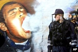 FILE - A member of the Copenhagen police patrols the enclave of Christiania in Copenhagen, Denmark, March 16, 2004. The hippies who turned the derelict naval base into a freewheeling neighborhood 50 years ago want to boot criminals out of the area.