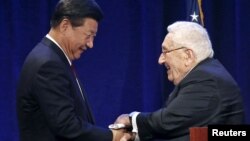 FILE - Chinese President Xi Jinping, left, shakes hands with former U.S. National Security Adviser and Secretary of State Henry Kissinger in Seattle, Washington, Sept. 22, 2015.