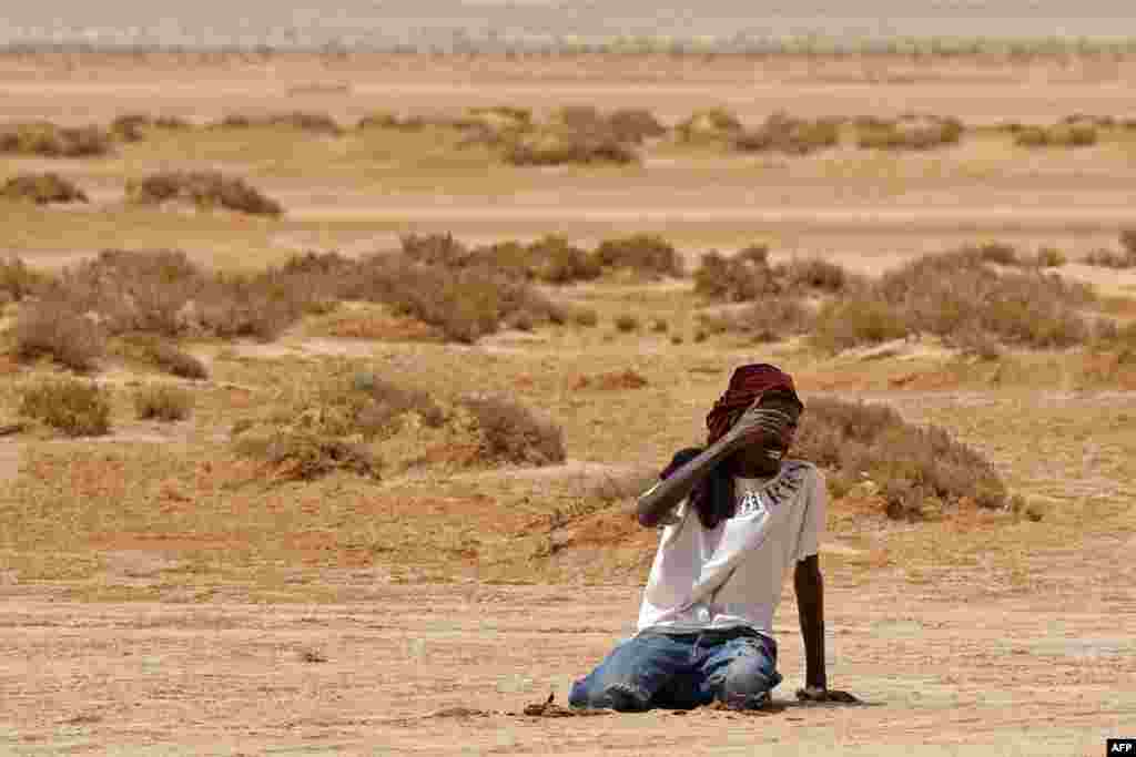 Мигрант од африканско потекло колабира поради исцрпеност и дехидрација по неговото пристигнување во ненаселена област во близина на Ал Асах на границата меѓу Либија и Тунис.