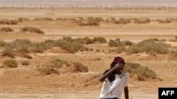 A migrant of African origin collapses due to exhaustion and dehydration upon his arrival in an uninhabited area near al-Assah on the Libya-Tunisia border.