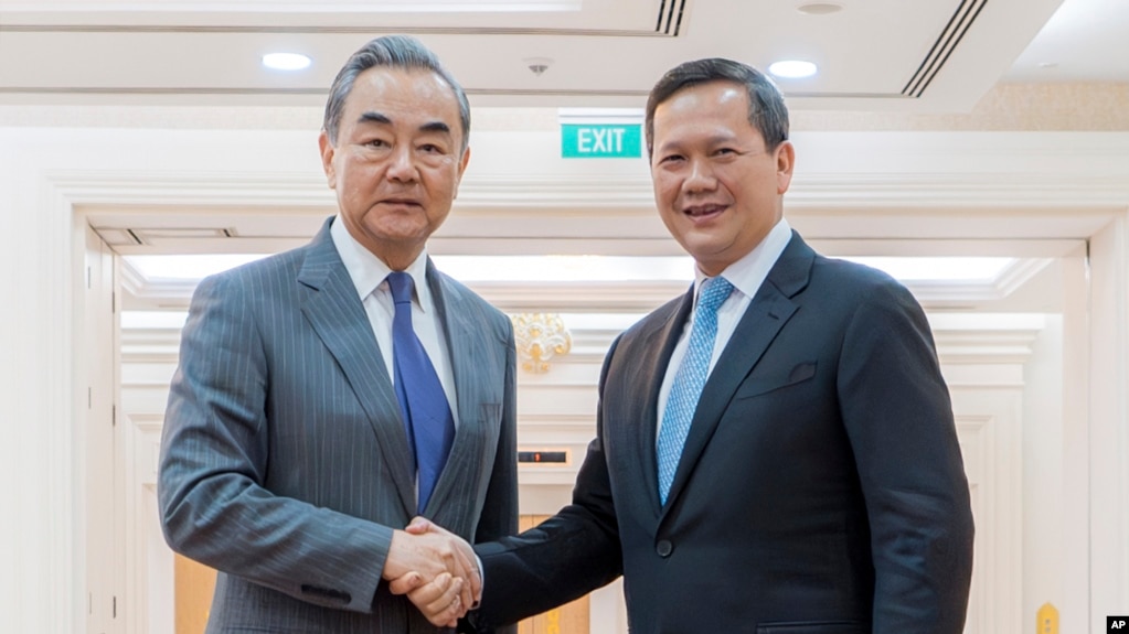 រដ្ឋមន្ត្រីការបរទេសចិនលោក Wang Yi និងនាយករដ្ឋមន្ត្រីកម្ពុជាលោក ហ៊ុន ម៉ាណែត ចាប់ដៃស្វាគមន៍គ្នា នៅវិមានសន្តិភាព រាជធានីភ្នំពេញ នាថ្ងៃទី២២ ខែមេសា ឆ្នាំ២០២៤។ (AKP via AP)