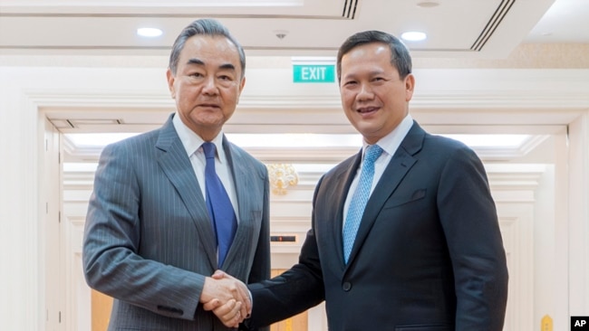 រដ្ឋមន្ត្រីការបរទេសចិនលោក Wang Yi និងនាយករដ្ឋមន្ត្រីកម្ពុជាលោក ហ៊ុន ម៉ាណែត ចាប់ដៃស្វាគមន៍គ្នា នៅវិមានសន្តិភាព រាជធានីភ្នំពេញ នាថ្ងៃទី២២ ខែមេសា ឆ្នាំ២០២៤។ (AKP via AP)