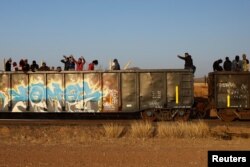 Migrants ride on a train towards Ciudad Juarez, in La Escuadra, Chihuahua, Mexico. March 28, 2023.