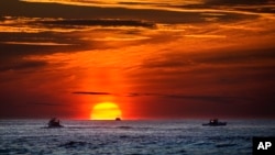 In this file photo, the sun rises over fishing boats in the Atlantic Ocean, Sept. 8, 2022, off of Kennebunkport, Maine. (AP Photo/Robert F. Bukaty, File)