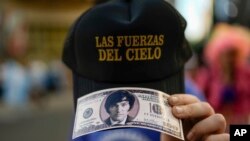 Mileijev pristalica sa kopijom novčanice od stolara koja nosi sliku novog predsednika Argentine (Foto: AP/Rodrigo Abd)