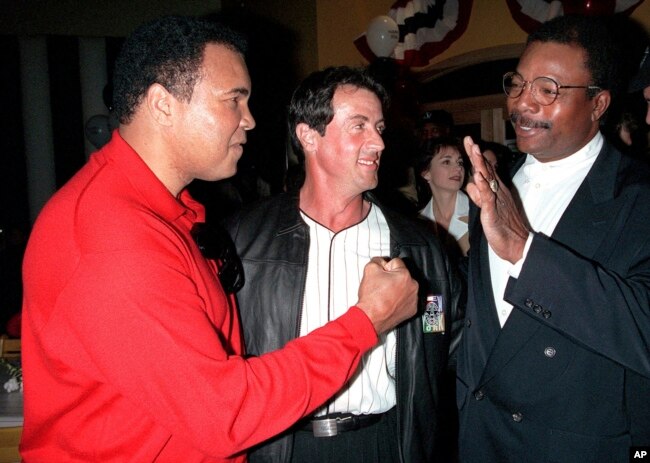 FILE - Former heavyweight boxing champion Muhammad Ali, left, joins Sylvester Stallone, center, and Stallone's