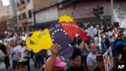 A woman holds a sign showing the Venezuelan map with the Essequibo territory included during the closing campaign on Venezuela Referendum on dispute territory with Guyana in Caracas, Venezuela, Dec. 1, 2023.