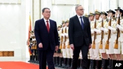 In this photo released by Xinhua News Agency, Australian Prime Minister Anthony Albanese, right, walks with Chinese Premier Li Qiang during a ceremonial welcome at the Great Hall of the People in Beijing, Nov. 7, 2023. (Liu Bin/Xinhua via AP)