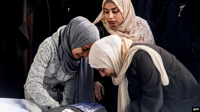 Palestinian women mourn over the wrapped body of a relative killed in overnight Israeli bombardment on the southern Gaza Strip at Al-Najjar hospital in Rafah on Feb. 8, 2024.