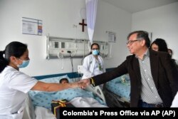 In this handout photo released by the Colombian Presidential Press Office, President Gustavo Petro greets a nurse tending to one of the four Indigenous children at a military hospital in Bogota, June 10, 2023.