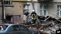 Un bombero ayuda a un hombre a sacar sus pertenencias de un edificio de apartamentos dañado por un ataque ruso en Sumy, Ucrania, el 3 de julio de 2023.