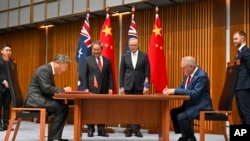 China's Premier Li Qiang, center left, and Australia's Prime Minister Anthony Albanese, center right, attend a signing ceremony at Parliament House in Canberra, June 17, 2024.