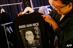 Seorang pria memegang kaos bergambar wajah calon Presiden Anies Baswedan, yang namanya diubah dari "Pak" Anies, menjadi nama yang lebih terdengar Korea "Park Ahn Nice" saat kampanye di Jakarta, 8 Februari 2024. (Yasuyoshi CHIBA / AFP)