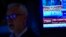A TV displays news about the Federal Reserve as traders work on the floor at the New York Stock Exchange in New York, June 14, 2023. 