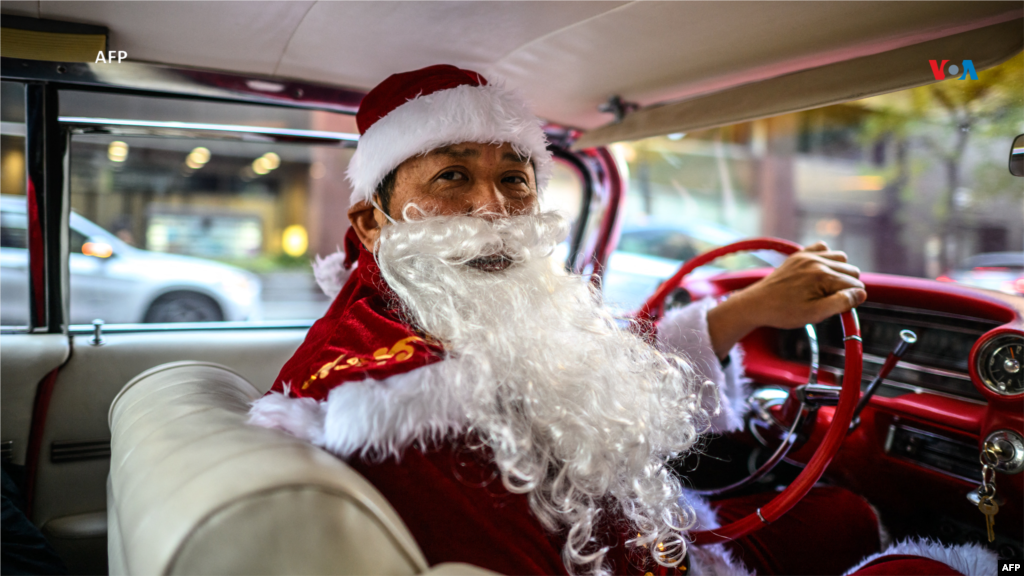 Desde Japón: Hiroyuki Wada, miembro de un grupo de autos antiguos, vestido como Papá Noel, conduce su Cadillac de 1959 antes de entregar regalos de Navidad al público en una calle del área de Marunouchi en Tokio el 24 de diciembre de 2023.