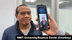 PhD scholar Guilherme Camargo de Oliveira demonstrates the face screening tool with Visiting Associate Professor Nemuel Daniel Pah, left, from RMIT University. (Credit: Seamus Daniel, RMIT University)