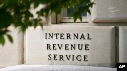 FILE - A sign outside the Internal Revenue Service building is seen, May 4, 2021, in Washington. 