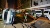 Police officers inspect damaged cars and the road after a suspected gas explosion injured people and caused significant damage, in the central business district of Johannesburg, South Africa, July 19, 2023.