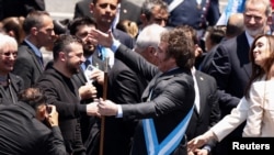 Ukraine's President Volodymyr Zelenskyy is greeted by Argentina's President Javier Milei following Milei's swearing-in ceremony, outside the National Congress, in Buenos Aires, Argentina, Dec. 10, 2023.