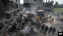 Warga Palestina mencari korban selamat setelah serangan udara Israel di sebuah bangunan tempat tinggal keluarga Yaghi di Deir al Balah, Jalur Gaza, Jumat, 23 Februari 2024. (AP Photo/Adel Hana)